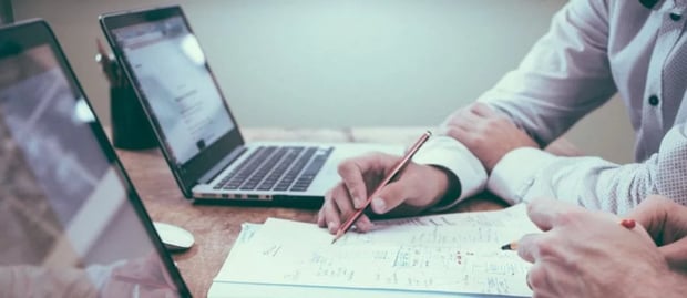 Two-Notebooks-on-an-Desk-and-Hands-920x400-1